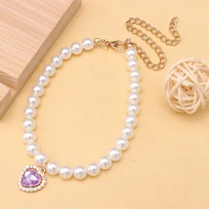 Close-up detail of a pet pearl necklace featuring an elegant purple heart crystal pendant