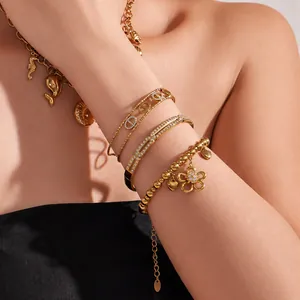 Detailed view of layered 18K gold-plated bracelets featuring zircon flower and CD motif