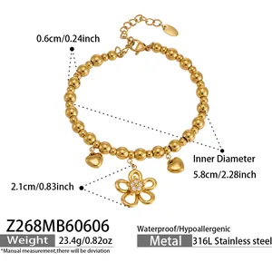Detailed view of gold-plated stainless steel beaded bracelet with flower zircon charm