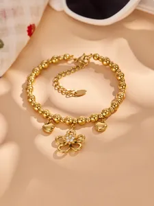 Detailed shot of a 18k gold plated stainless steel beaded bracelet featuring a zircon flower