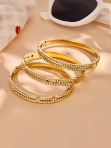 Close-up of three 18k gold plated pig nose bracelets with sparkling zircon stones