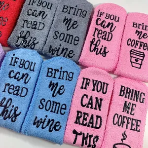 Close-up of fuzzy coral fleece socks with anti-slip rubber 'Bring Me Wine' text print