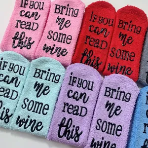 Detailed view of fuzzy coral fleece socks featuring funny Bring me some wine non-slip soles