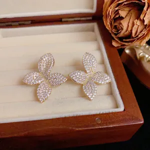Detailed macro view of gold-tone petal earrings fully paved with sparkling crystals