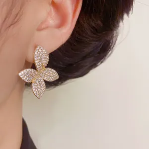 Close-up of sparkling butterfly stud earring with full zircon pavé in gold finish