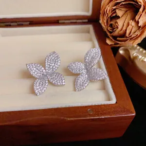 Sophisticated full diamond flower petal stud earrings displayed in a luxury wooden box