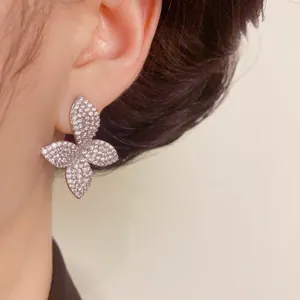 Oversized butterfly stud earrings encrusted with sparkling rhinestones worn on ear
