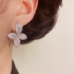 Close-up detail of silver butterfly stud earrings featuring brilliant full rhinestone pavé.