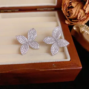 Detailed macro view of sparkly pavé diamond flower petal stud earrings in jewelry box.