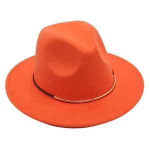 Detail view of a vibrant orange wool felt fedora with a gold decorative band