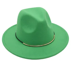 Detail view of a green wool felt fedora jazz hat with a gold metal band decoration.