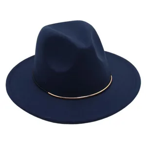 Close-up detail of a navy blue wool felt fedora hat featuring a stylish gold metal band.