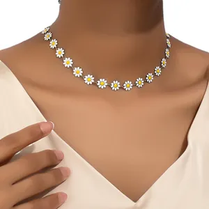 Elegant white enamel daisy flower necklace with yellow centers worn by a fashion model