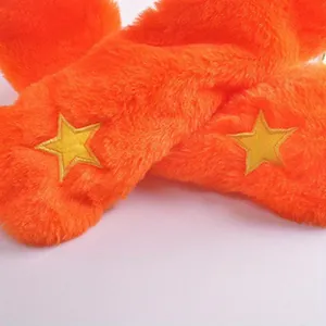 Close-up detail of the orange plush fur and yellow embroidered stars on a pumpkin hat