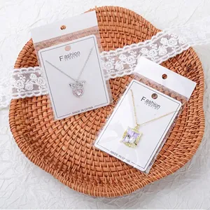 Close-up detail view of fashion pendant necklaces shown in original jewelry packaging