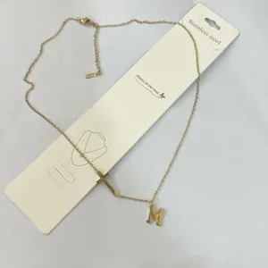 Dainty gold stainless steel necklace with letter M pendant and small cross charm