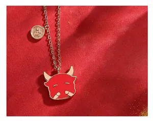Detail shot of a red cartoon bull head necklace with gold accents on red background