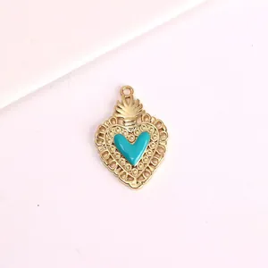 Detail view of vintage gold heart pendant featuring turquoise enamel inlay and filigree border.