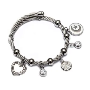 Vue détaillée d'un bracelet câble en acier inoxydable avec des breloques cœur et étoile lune