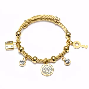Détail d'un bracelet câble en acier inoxydable doré avec breloques de luxe élégantes