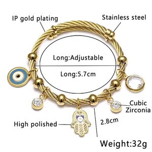 Vue détaillée d'un bracelet en acier inoxydable doré avec Evil Eye et breloques Hamsa.