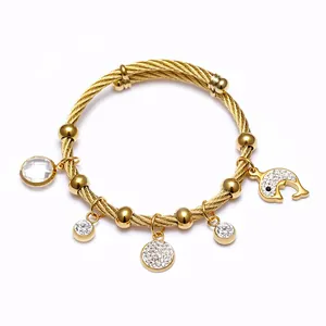 Vue détaillée du bracelet en acier inoxydable doré avec breloques dauphin et cristaux