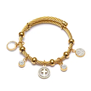 Vue détaillée d'un bracelet câble en acier inoxydable doré 18 carats avec croix et cristaux
