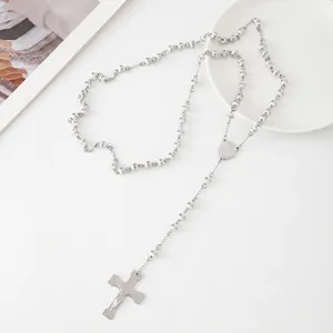 Detailed view of silver stainless steel rosary necklace with white beads and crucifix