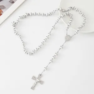 Close-up detail of a white beaded stainless steel rosary necklace with cross pendant