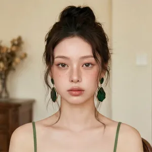 Detail shot of retro emerald green irregular drop earrings on an Asian model