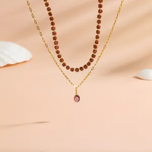 Elegant layered goldstone bead necklace with a purple oval pendant on a gold chain.