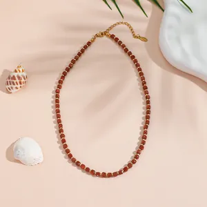 Non-tarnish titanium steel necklace with brown goldstone beads in a flat lay setup