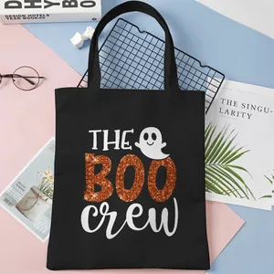 Black canvas tote bag featuring Boo Crew Halloween glitter graphic and ghost illustration