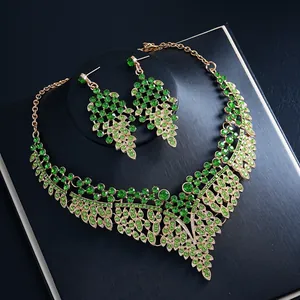 Macro-opname van elegante goudkleurige ketting- en oorbellen set met groene kristallen