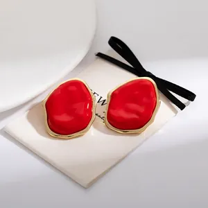 Chic red irregular geometric stud earrings with elegant gold trim detail, fashion style