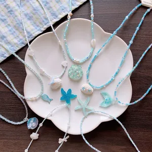 Summer island beaded necklace set with shell and starfish pendants on white plate