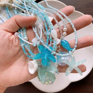 Summer island blue and white beaded necklace with starfish and shell charms in hand