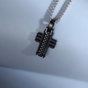Detailed macro view of a black checkered cross pendant on a silver chain