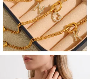 Detail of gold stainless steel knot bracelet with sparkling crystal letter charms