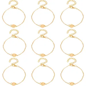 A detailed view showing nine different golden initial bracelets with engraved round letter discs