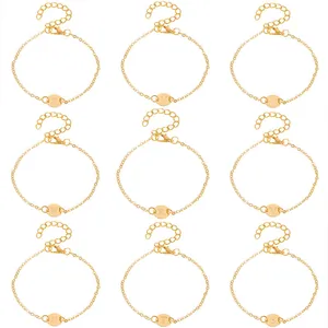 Detailed view of nine gold chain bracelets with engraved capital letter round charms