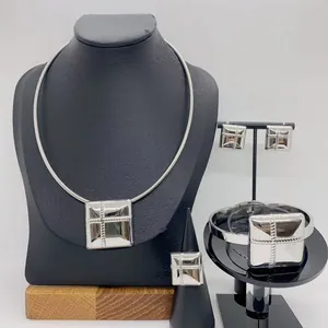 Detailed macro view of silver stainless steel jewelry set featuring square cross patterns