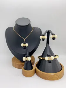 Detailed view of women's stainless steel jewelry set on black display stands