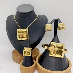 Elegant gold stainless steel jewelry set featuring geometric square pendant and accessories