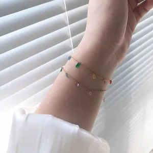Close-up detail of a dainty gold titanium steel bracelet featuring multi-colored zircons.