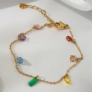 Close-up of gold titanium steel bracelet with seven colorful rainbow zircon stones.