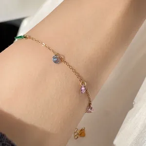 Elegant minimalist gold titanium steel bracelet with colorful faceted zircon charms on wrist