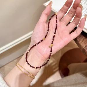 Elegant natural dark red garnet beaded bracelet featuring delicate gold-tone accents and charm
