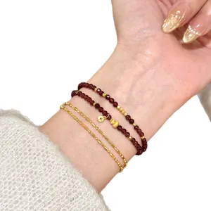 Elegant natural red garnet beaded double-layered bracelet with gold charms on wrist