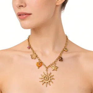Gros plan d'un collier bohème doré avec pendentifs soleil et étoile sur le cou d'une femme